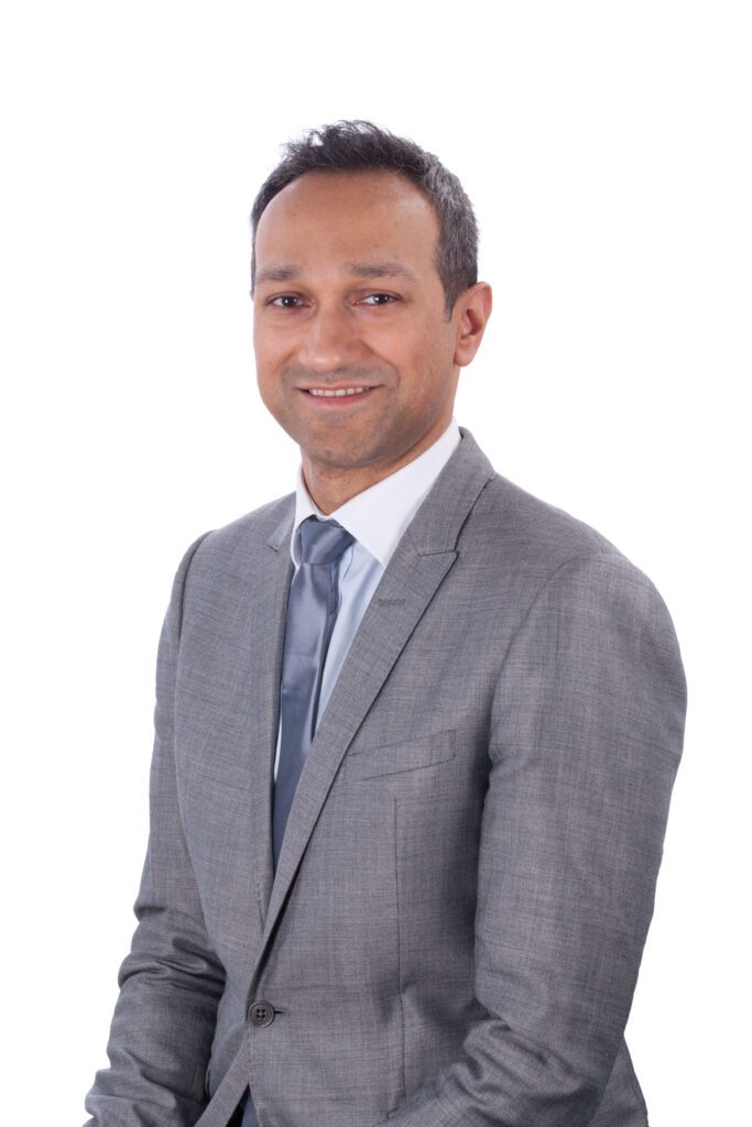 Photograph of Prof Amit Patel wearing a light grey suit and pale blue tie
