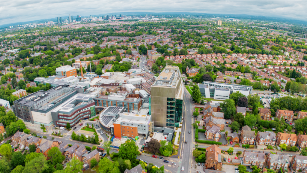 The Paterson Building on the Christie Hospital site in Withington, Manchester, with the Oglesby Cancer Research Building, the Proton Beam Centre and the wider Manchester cityscape